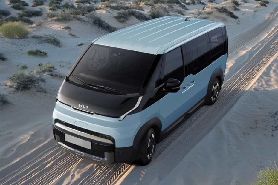 Kia PV5 electric van driving on desert road top view